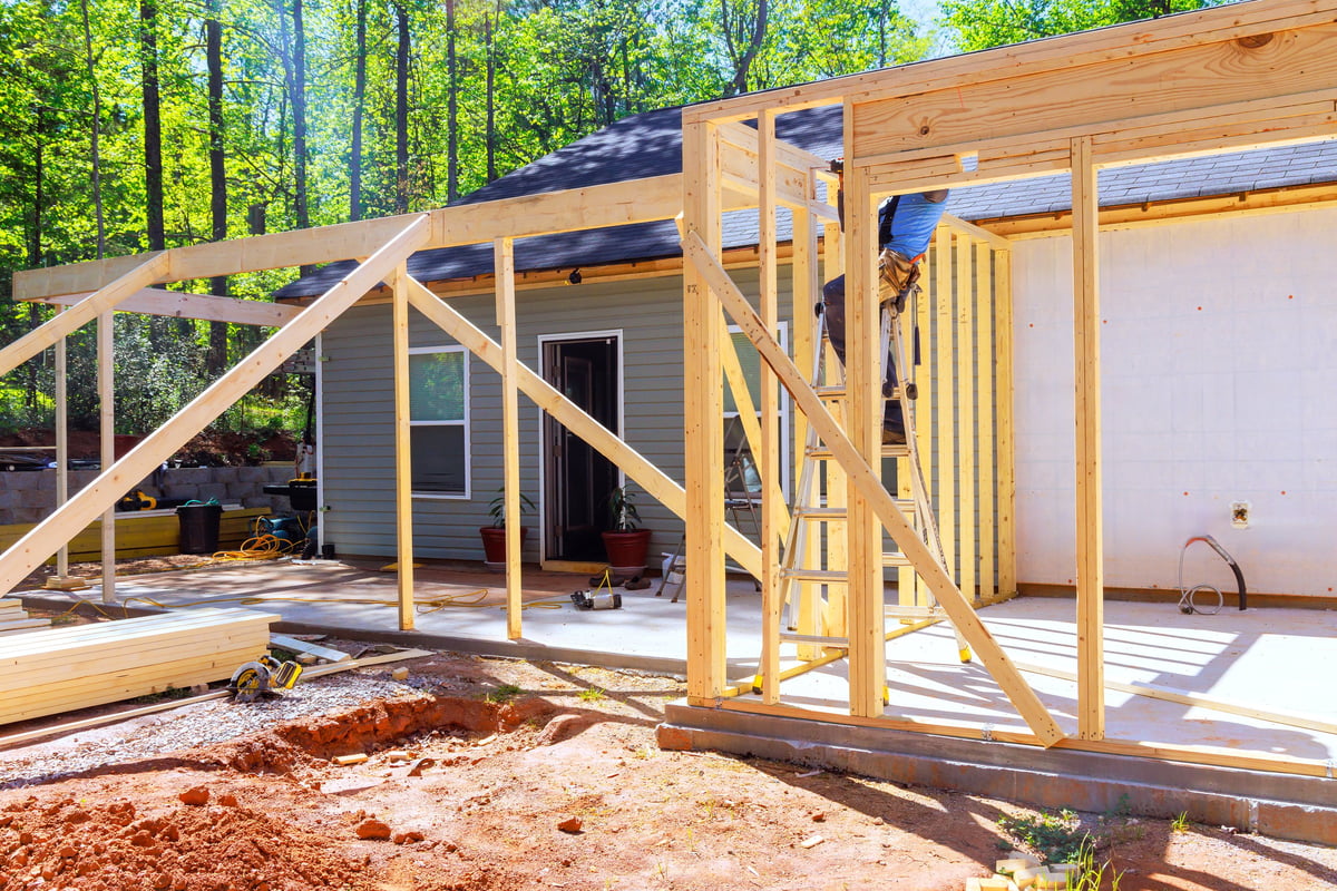 Workers installing wooden trusses framing for a home addition in Ontario